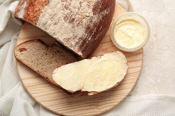 Fresh bread with butter on light background