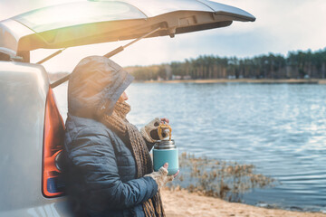 Woman is eating a hot dish from a thermos