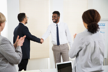 Business people congratulate their colleague of the success on the business seminar.
