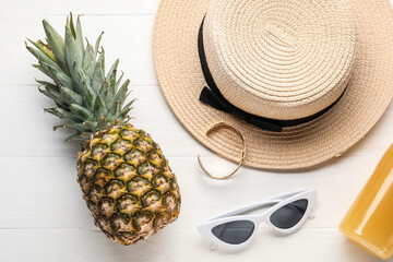 Pineapple with female accessories on white wooden background