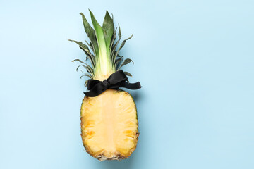 Pineapple with bow on color background
