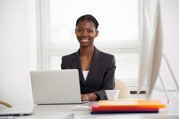 Portrait of african american business woman looking at camera at workplace in an office