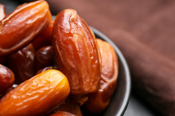 Bowl with sweet dried dates on table, closeup