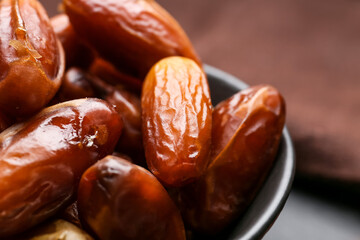 Bowl with sweet dried dates on table, closeup