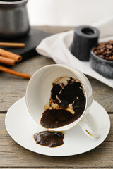 Cup with spent coffee grounds for fortune telling on table