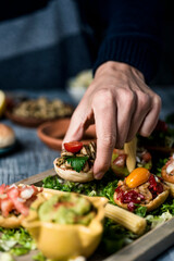young man takes a vegan appetizer from a tray