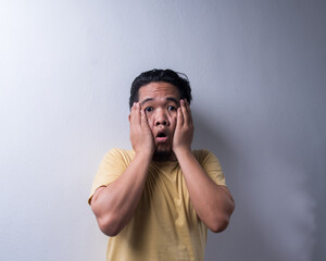 Face reaction, Asian young man portrait of face expression, shocked, thrilled, scared, surprised, with covered face with hand. Isolated, selective focus, copy space
