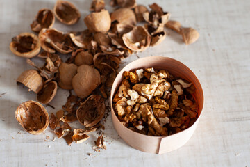Fototapeta na wymiar large horizontal photo. Walnut. Peeled walnut grains with shells. Dry shell. Harvest of nuts. White table. Vitamins. Healthy eating. ECO.