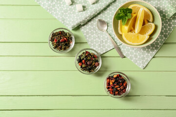 Composition with dry green tea and lemon on color wooden background