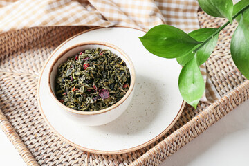 Bowl of green dry tea on tray