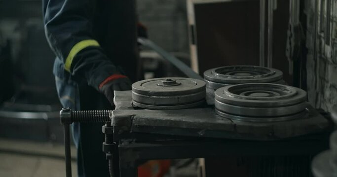 Locksmith bends a metal profile along a certain radius on a bending machine, metalwork at blacksmith's workshop, 4k 60p Prores HQ