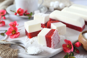 Homemade panna cotta and red fruits cubes in coconut flakes and coffee