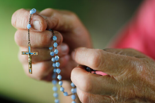 Close-up of a man's hands praying the rosary, France