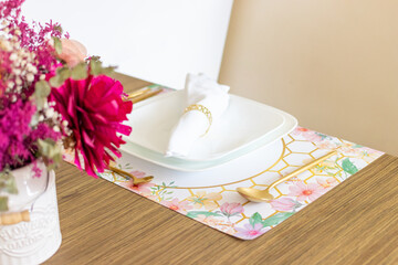 Plate and utensils, on the table decorated with a small flower arrangement