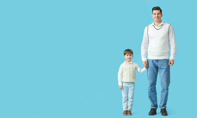 Happy father and his little son on color background