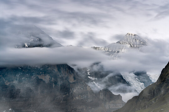 The Eiger and Monch mountain peaks in the cloudy sky, Mannlichen, Grindelwald, Bernese Oberland, Bern Canton, Switzerland