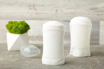 White deodorants with flower on light background.