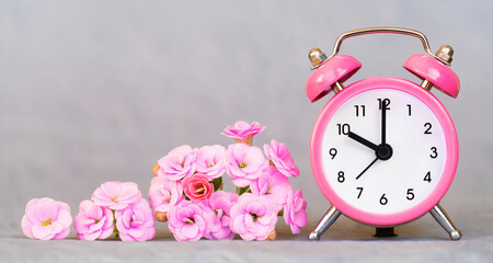 Banner of pink flowers and clock watch on grey background. Spring,  summer or mothers day concept.
