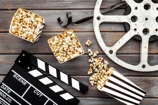 Layout of film reel with popcorn and clapperboard. Cinema concept