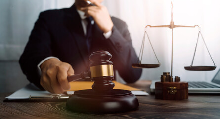 Business and lawyers discussing contract papers with brass scale on desk in office. Law, legal services, advice, justice and law concept picture with film grain effect