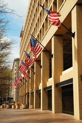 American Flag fly from the front of the FBI Headquarters building in Washington, DC