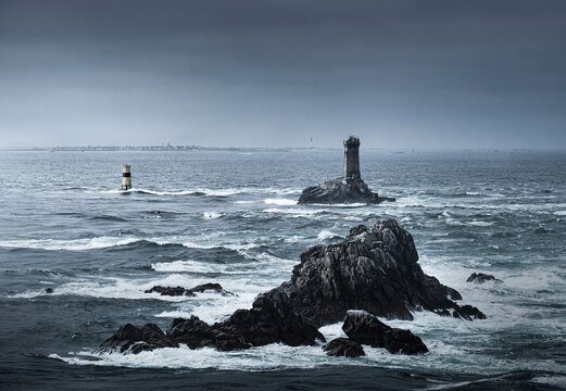 View of the ocean at Pointe du Raz with two lighthouses, Phare de la Vieille and Tourelle de la Plate (Petite Vieille), in the sea and rocks, Finistere, Brittany, France