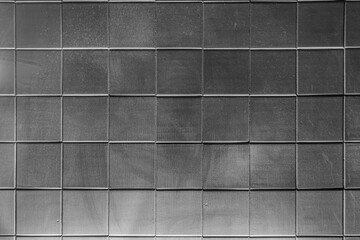 The texture of square glossy uneven ceramic tiles. Bottom hard dark lighting.