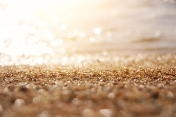 background image of sandy beach and ocean waves with bright bokeh lights