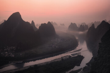 Pink sunrise on the Li River and the famous Yangshuo mountains, Yangshuo, Guangxi, China