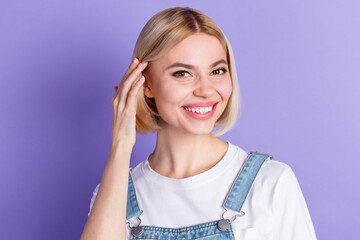 Fototapeta premium Photo of nice optimistic short hairdo blond lady touch hair wear white t-shirt isolated on violet color background