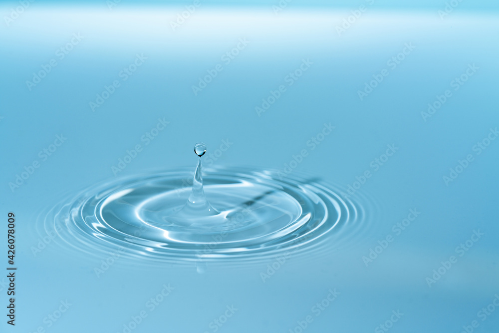 Wall mural drop of water drop to the surface. waves on the surface of the water from a collision