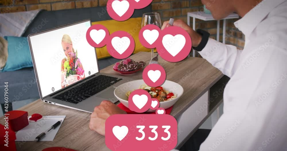 Poster heart icons and increasing numbers against man having lunch while having a video call on laptop