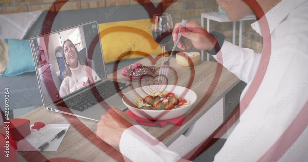 Sticker Concentric red hearts over caucasian man having lunch while having a video call on laptop