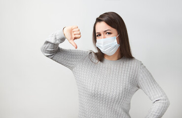 Young woman wearing medical mask, white background.