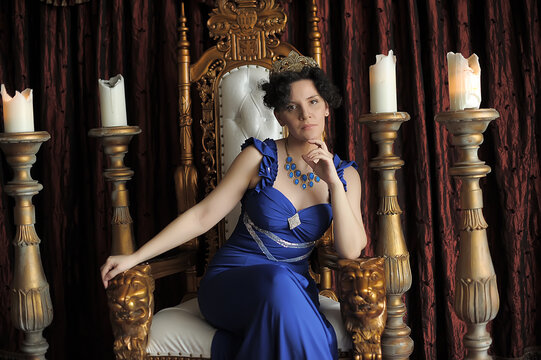 brunette on a gilded throne surrounded by candles