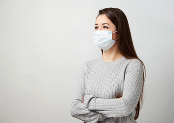 Young woman wearing medical mask, white background.