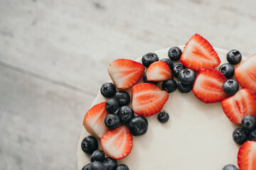 Cream cheese cake with berries. Homemade strawberry and blueberry cake. Place for your text. Cake close-up