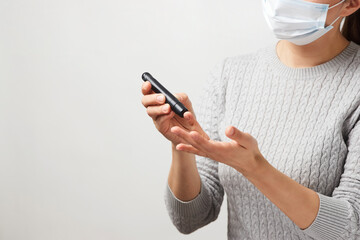 Young woman testing her blood sugar level, close-up