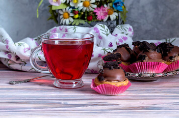 Three cakes on a saucer and a cup of tea close-up