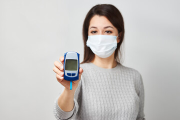 Woman with blood glucose meter, close-up