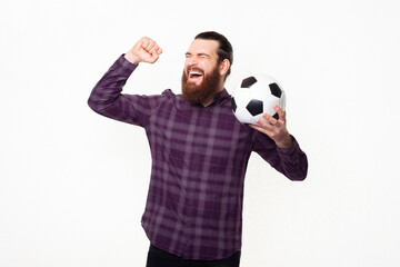Naklejka premium Amazed cheerful man in checkered shirt celebrating and supporting favorite team