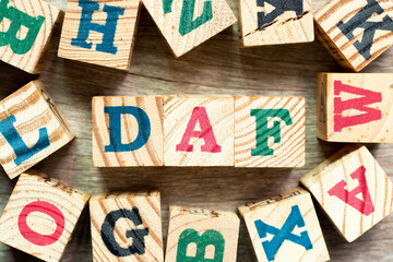 Alphabet letter block in word DAF (Abbreviation of Delivered at frontier) with another on wood...