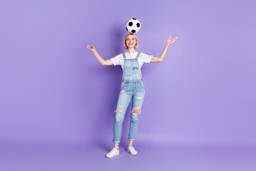 Full length photo of young girl happy positive smile hold soccer ball head have fun isolated over...