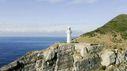 Fototapeta na wymiar 五島列島の崖に立つ灯台。ドローンで空中撮影。