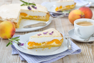 Leckerer Pfirsich-Tarte mit Lavendelhonig und Baiserhaube sowie einem Cafe Creme auf einem Holztisch  mit Deko - Peach pie with lavender honey topped with sweet meringue served  with a cup of coffee