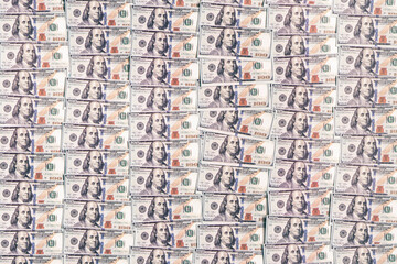 a lot of paper bills of American dollars on the background. One hundred dollars pile as background.