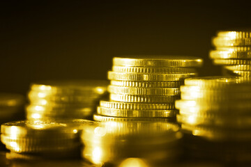Group of golden coin stacking in vertical row shallow focus with fill in frame with gold coin blur background, rows of coins for finance and banking. finance and business concept.