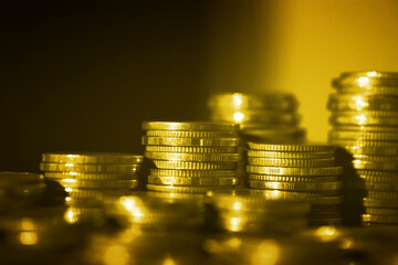 Group of golden coin stacking in vertical row shallow focus with fill in frame with gold coin blur background, rows of coins for finance and banking. finance and business concept.