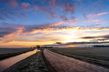 Quiet colorful sunrise with orange and pink sky during the winter in Giethoorn, the Netherlands.