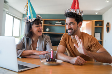 Couple celebrating birthday on a video call at home.